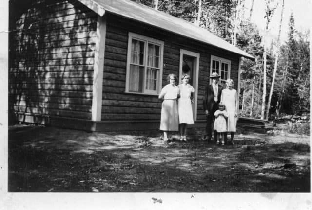 5 people standing next to a house