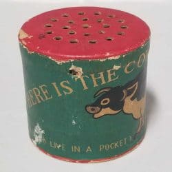 Green tube with a red lid with holes. The words 'Where is the cow' is written on it.