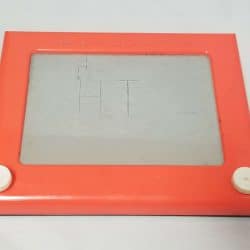 Red Etch a Sketch with the word Hi written on it.