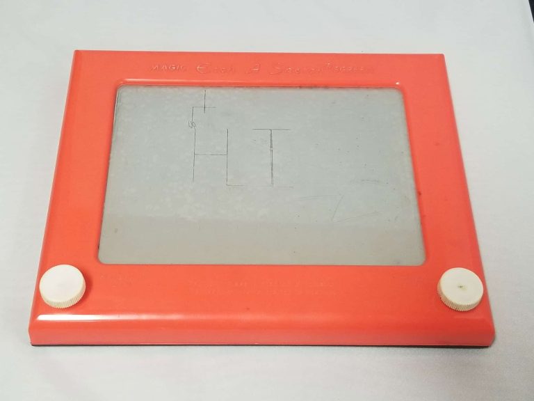 Red Etch a Sketch with the word Hi written on it.