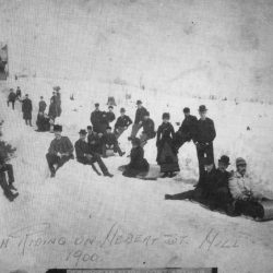 Many people posed along a hill for sledding from 1900