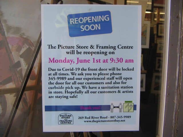 Sign on a doorway saying Reopening Soon.  Mentions the front door will be locked at all times and to call to be let in. Sanitation stations available in store.