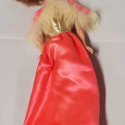 Barbie doll wearing a coral and gold dress, fur-lined cape, and shoes that lace up her calves.