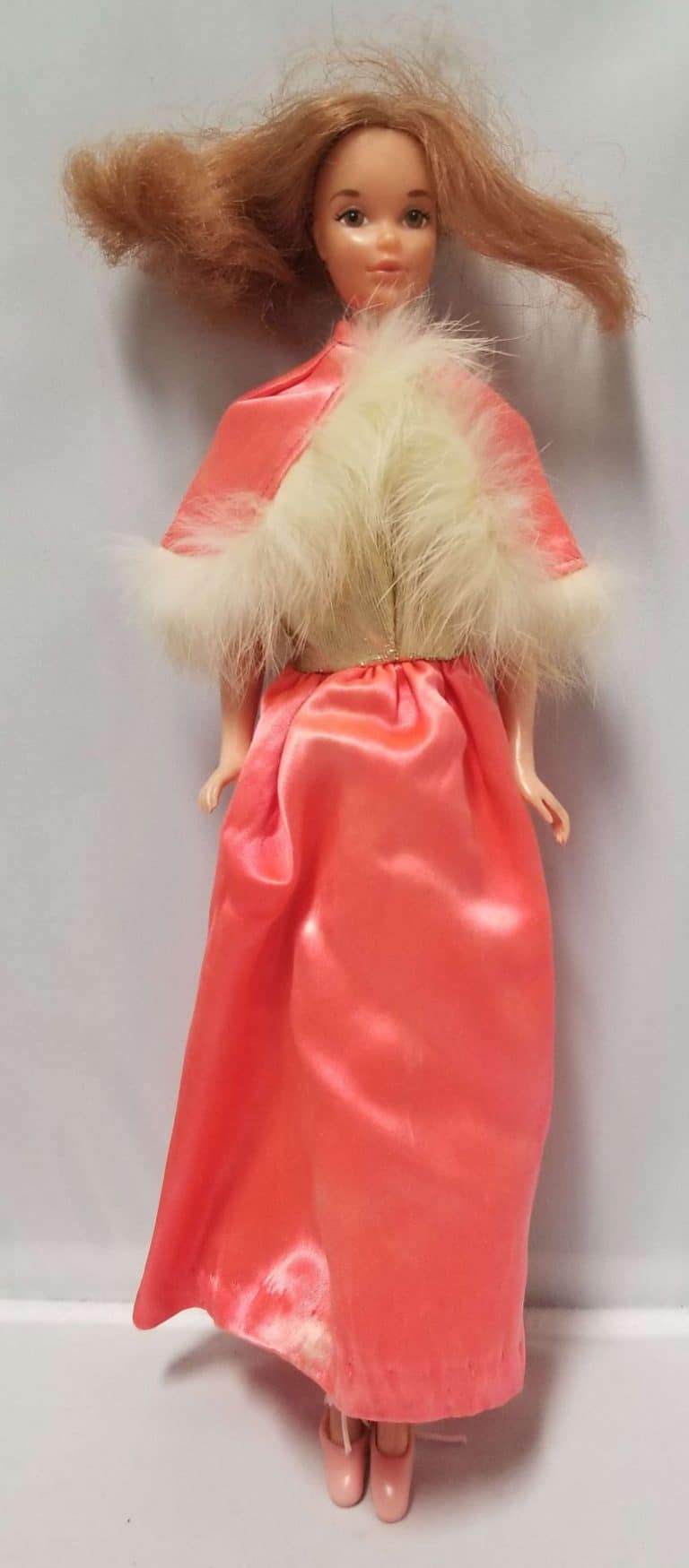Barbie Doll with brown hair, wearing a coral dress with a fur-lined cape.