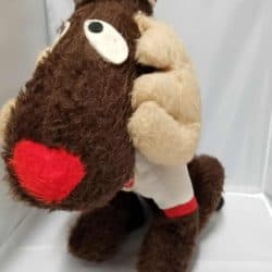 Stuffed Moose with a striped white and red hat wearing a white sweater with red cuffs.