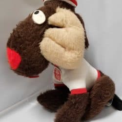 Side view of the Canada Games Complex Moose mascot seen from the side. Wearing a striped red and white hat and a white sweater with red cuffs and a sewn badge on the front of the sweater of the Canada Games Complex logo.