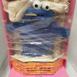 Blue Cookie Monster puppet still in box, wrapped in plastic.