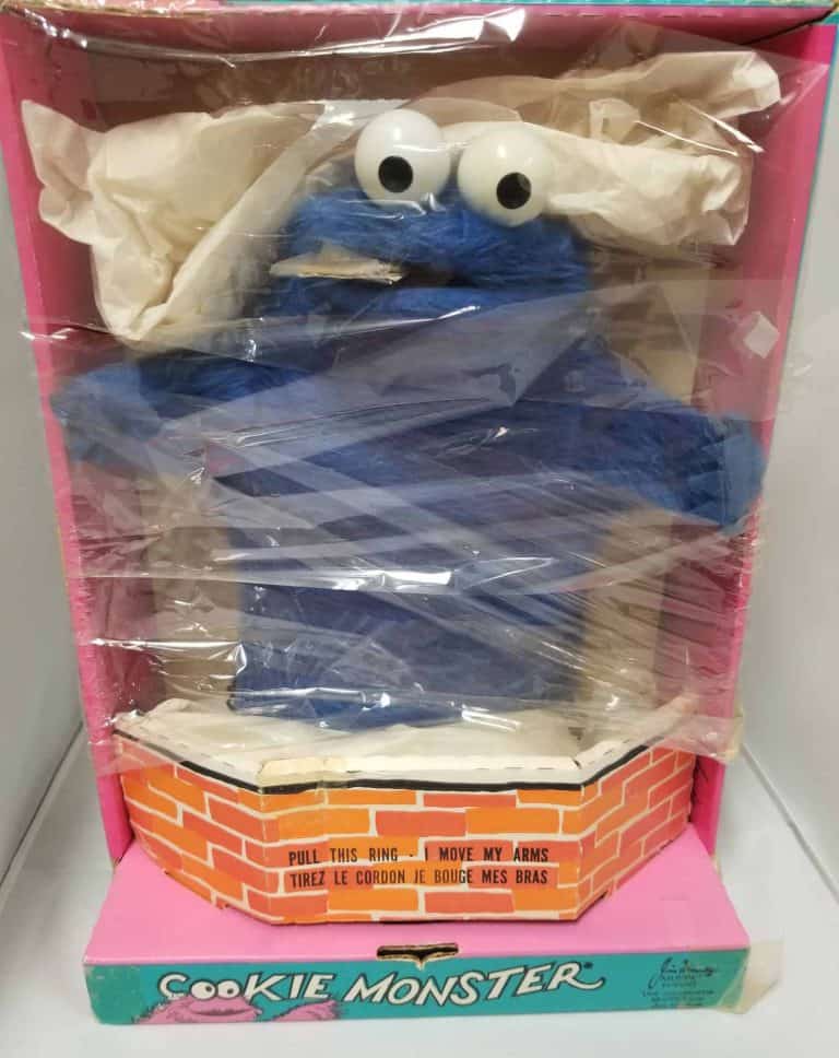 Blue Cookie Monster puppet still in box, wrapped in plastic.