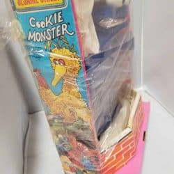 Side of Cookie Monster's box. Also features other Sesame Street characters such as Big Big, Oscar the Grouch, Bert, and Ernie.