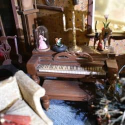 Piano in the living room with various decorations on top.