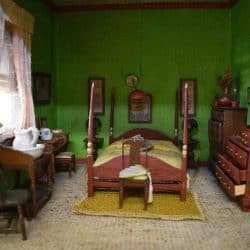 Bedroom with green walls and a 4 poster bed.