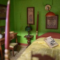 Side table next to the bed in a green bedroom.