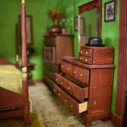 Open dresser drawers in a green bedroom.