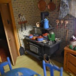 Old wood stove with various pots on top.