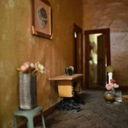 Flowers in a vase and an old sewing machine along one wall.