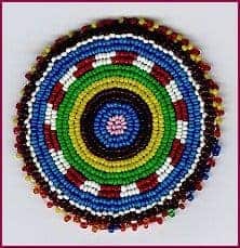 Seed beads in circular pattern on wool and cotton with paper backing for support.