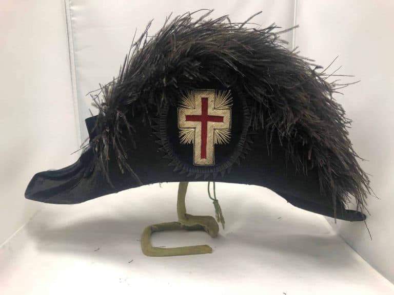 Hat with a black fur top with a cross embroidered on the side