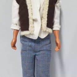Ken doll wearing a brown vest over a white long sleeve shirt and blue houndstooth pants.