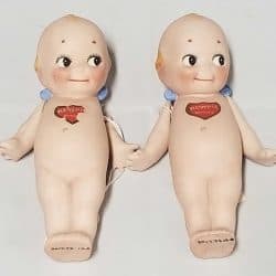 Two Kewpie Dolls laying down.