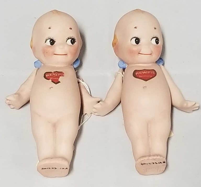 Two Kewpie Dolls laying down.