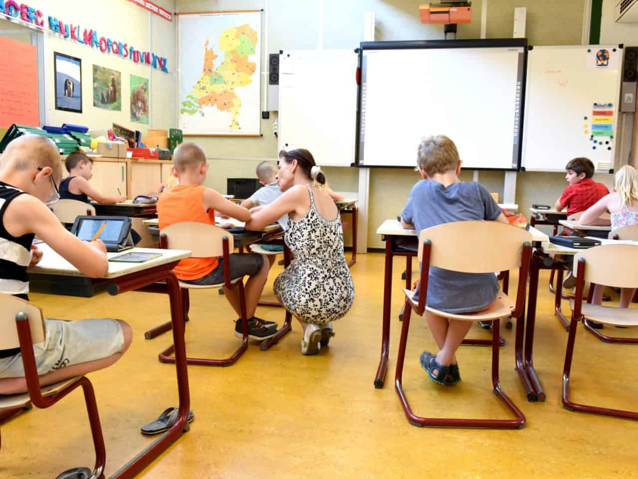 Teacher in a classroom of young students.