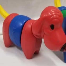 Plastic dog puzzle with a red head, blue body, red bottom, and yellow tail.