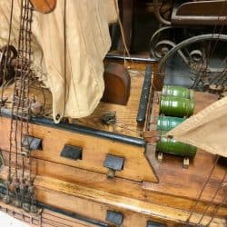 Wooden ship with sails on the masts and barrels on the deck