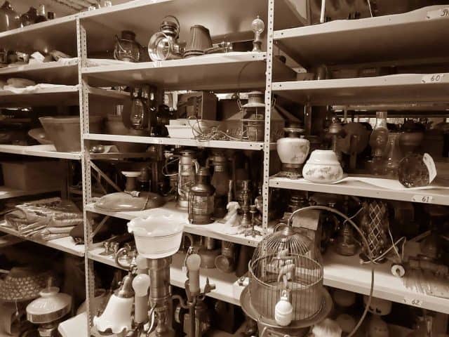 Shelves of donated lamps, lanterns, and light fixtures.