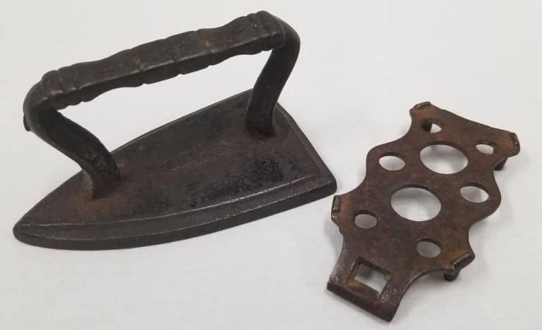 Toy metal iron and trivet circa 1895.