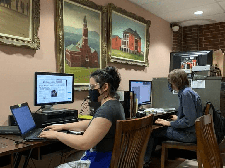 Volunteers sitting at computers working to digitize items