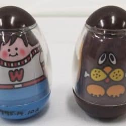 Two weebles. On the left a boy and on the right a dog.