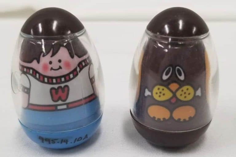 Two weebles. On the left a boy and on the right a dog.