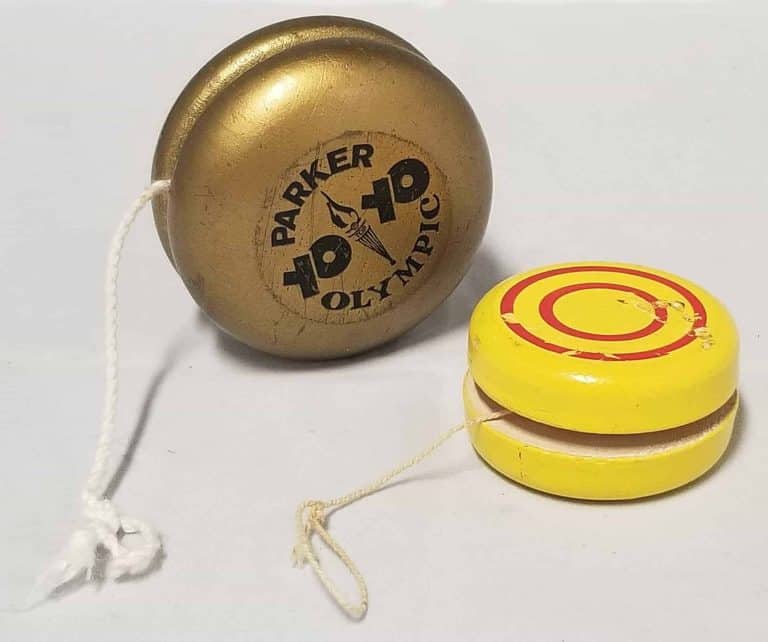 Two yo-yos, one gold, one yellow with red circles on it